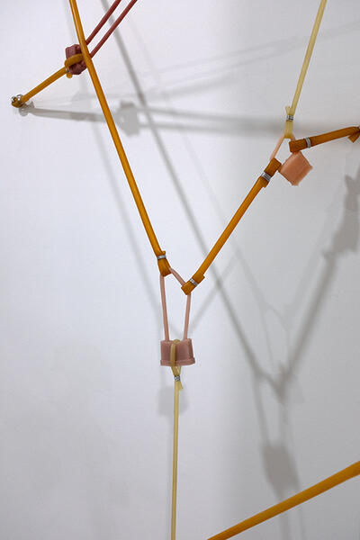 Locked stretch, 2025. latex tubing, silicone, hardware, dumbbell 90”x 40”x 8”
