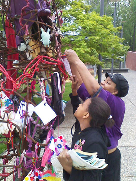 Hand of Creativity ( detail) shows a Black mother and her daughter adding objects to the sculpture