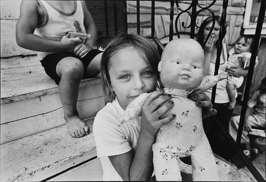 photograph of girl holding doll and boy holding gun in South Baltimore City