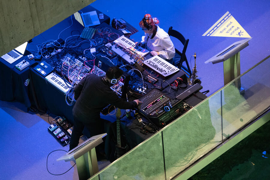 two performers at a table of synthesizers