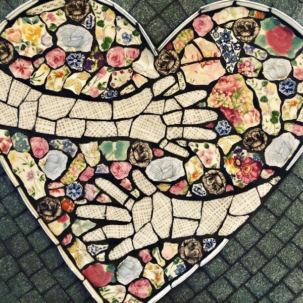 mosaic heart with hugging arms created with broken dishes and glass tiles