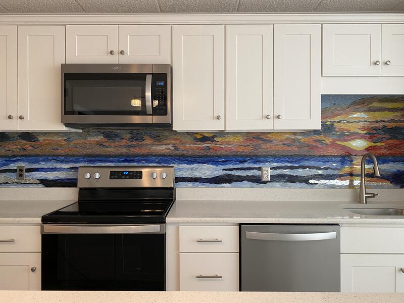 backsplash depicting a sunrise over the ocean created from hand cut pieces of stained glass