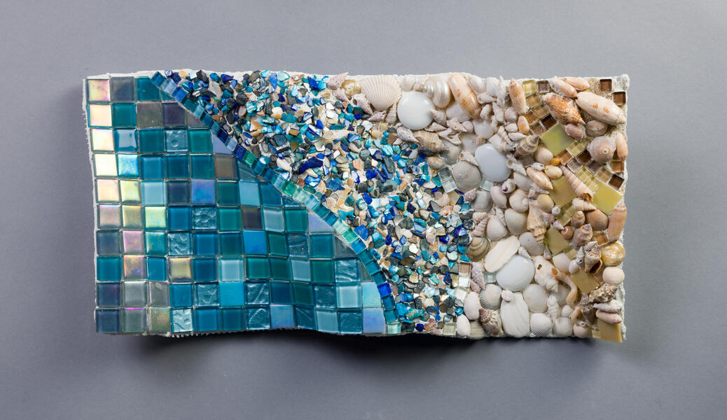 Abstract mosaic made with glass tiles and shells on a handmade undulating substrate depicting a beach scene