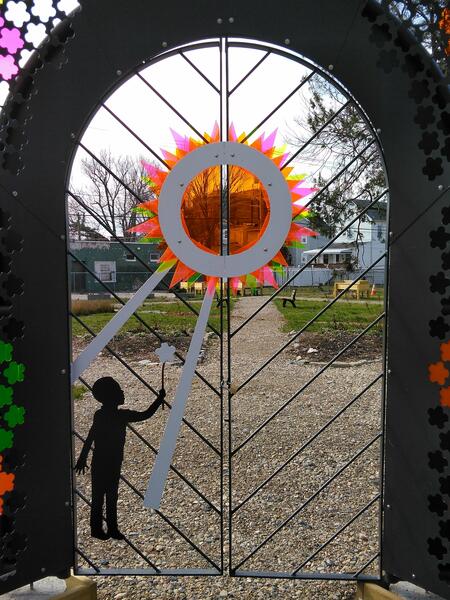 Garden Gate - Child offers gift to the sun for all it gives us.
