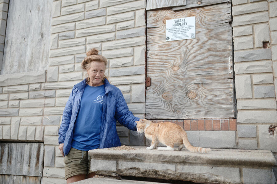 A woman feeds a cat in Mount Clare.