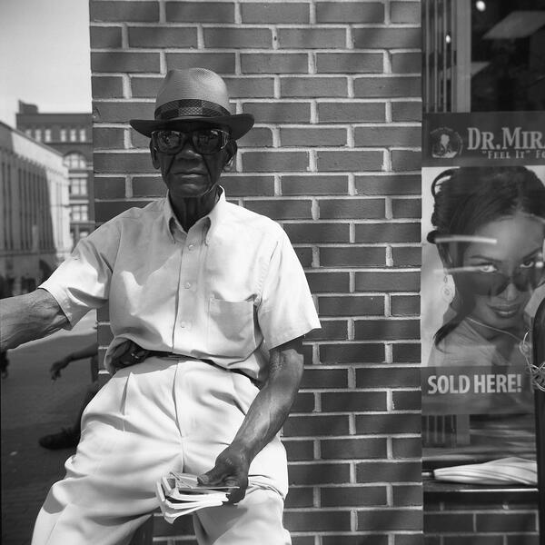 A man handing out prayer books in Lexington Market.