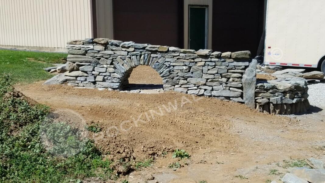Limestone freestanding wall ach with boulders