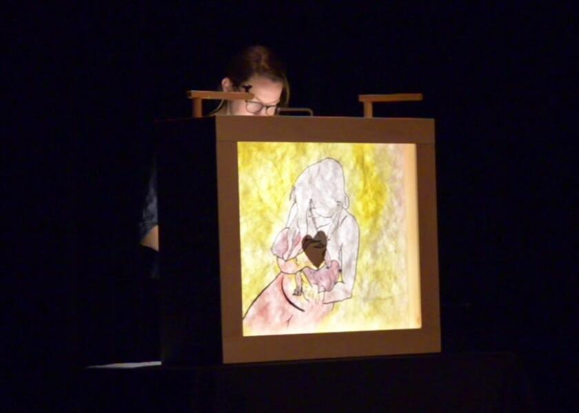 A drawing seen with light projected behind it of the moment my child is born and placed in my arms.