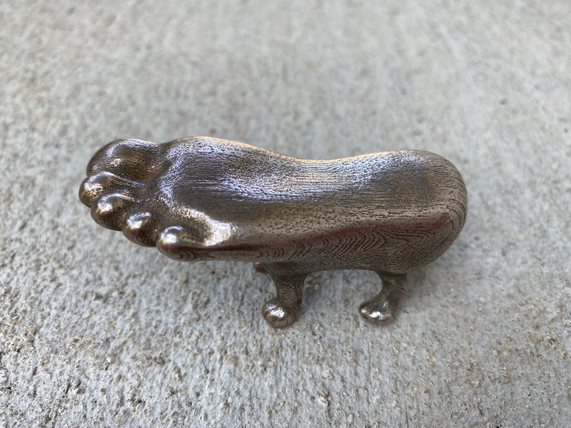 A brass foot with dog legs