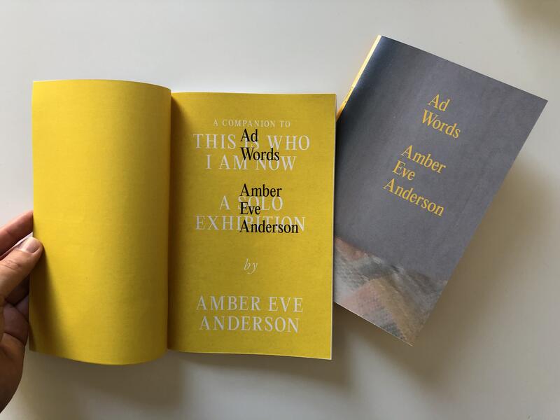 Book titled "Ad Words" lying on a table with a second copy open to two interior yellow pages