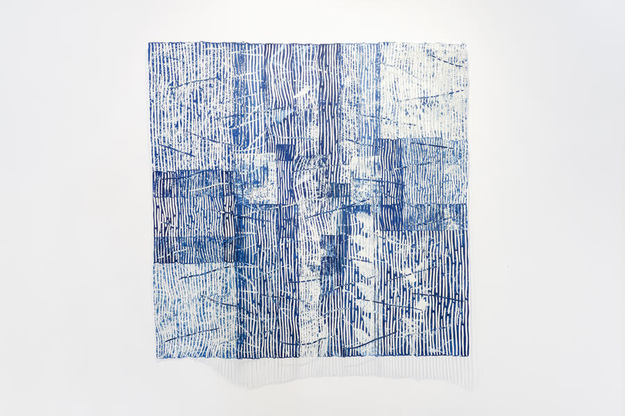 Collaged blue and white paper with wavy lines overlapping each other in a large square.