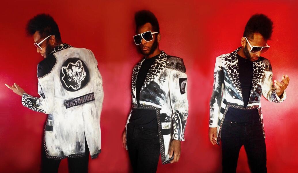 Photo of Landis Expandis modeling in three views, wearing his hand painted tails jacket with a wolf head on the back with the word "VICTORIOUS" beneath.